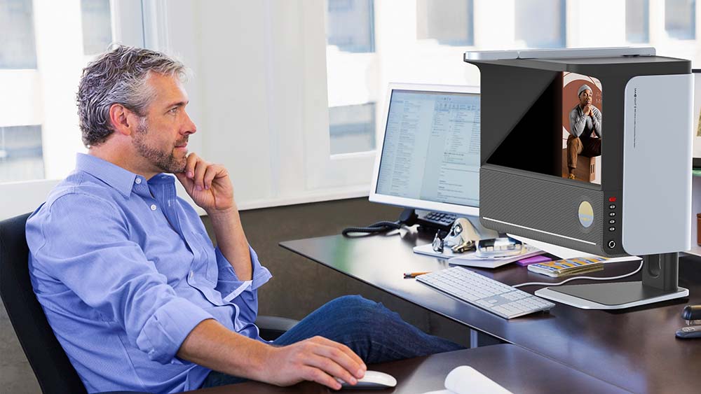 A man working at an office desk beside a MAXIGHT Pro Edition